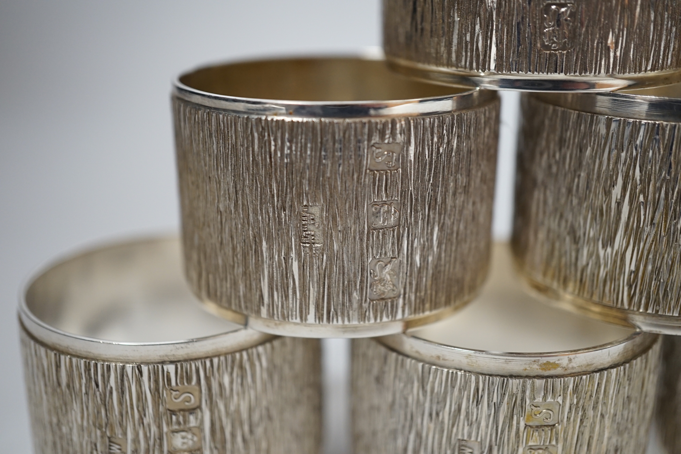 A set of six Elizabeth II textured silver napkin rings, Mappin & Webb, London, 1973, 46mm, 10.9oz, with Mappin & Webb box.